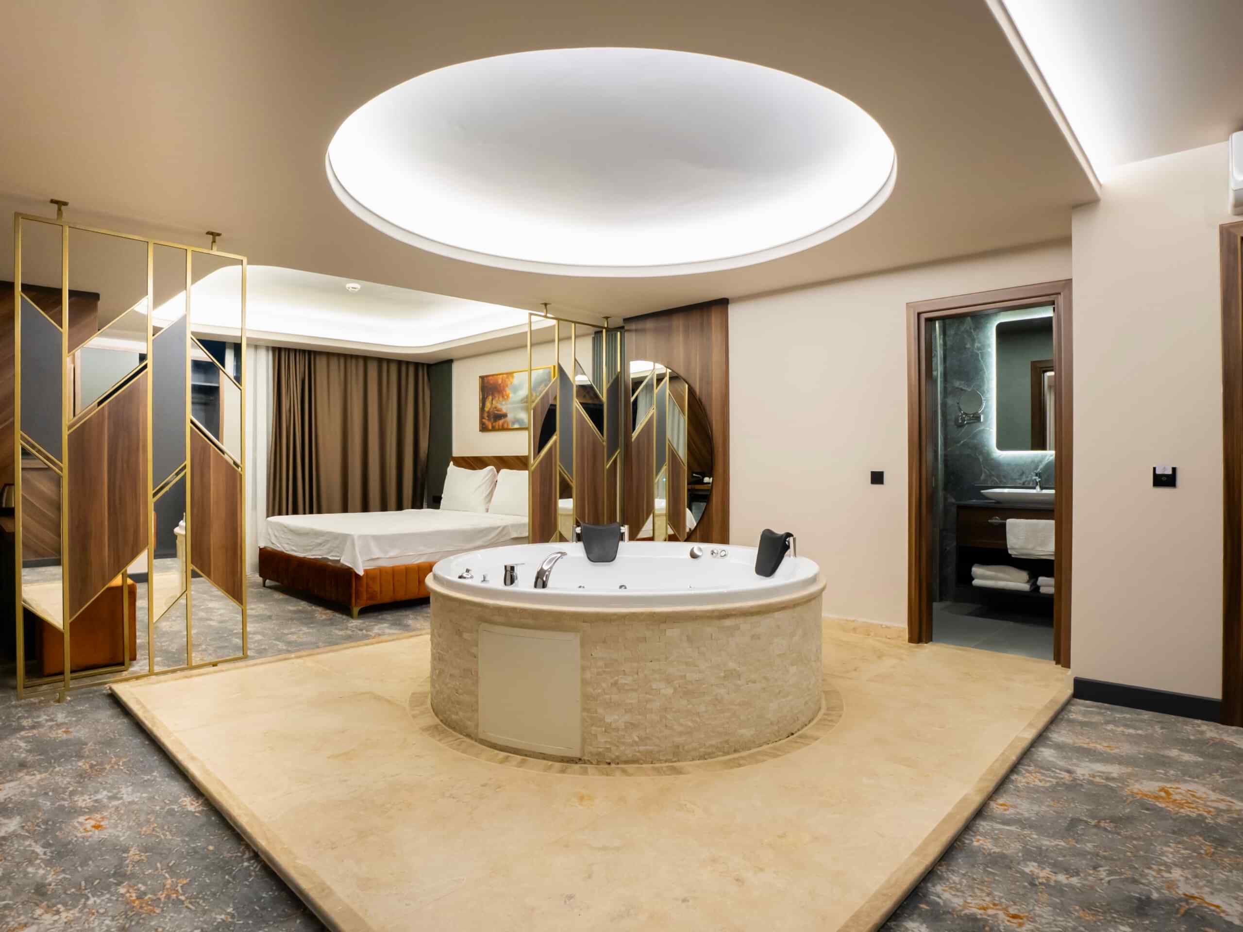 Misafir suit odası — yatak, jakuzi ve banyo girişi